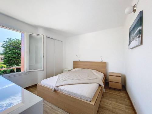 une chambre blanche avec un lit et une fenêtre dans l'établissement Appartement en bord de plage avec terrasse, parking privé, wifi et équipements modernes - FR-1-770-15, à Saint-Cyr-sur-Mer