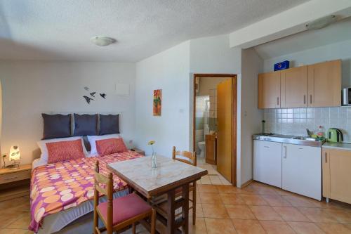 a room with a bed and a table and a kitchen at Vila DADA 2 in Senj