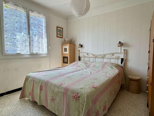 una camera con un letto con una coperta rosa e bianca di Appartement familial climatisé avec terrasse, 2 chambres, à 8 km de la mer - Sorède - FR-1-225-737 a Sorède