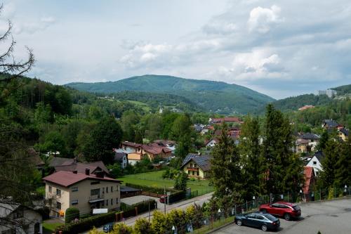 a town with cars parked on a street with mountains at Hotel Jarzębata in Wisła