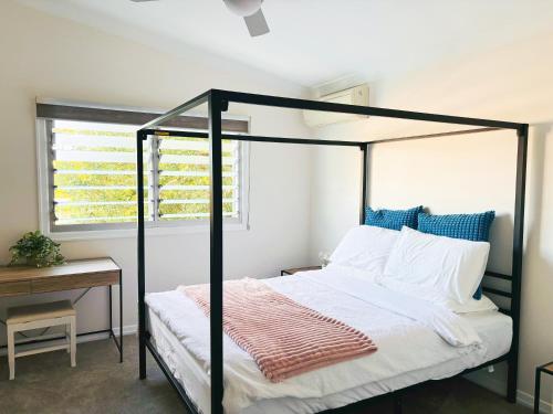 a bedroom with a black canopy bed with a window at Elegant Villa Near Shopping Mall in Jindalee