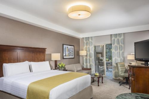 a hotel room with a bed and a television at Ayres Hotel Laguna Woods - Aliso Viejo in Laguna Woods