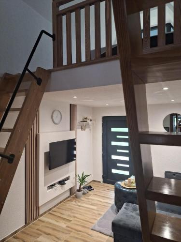 a living room with a staircase and a television at Oaza mira 1 in Jajce