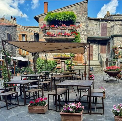 a patio with tables and chairs and flowers at Flat Ghino di Tacco historical centre Radicofani in Radicofani
