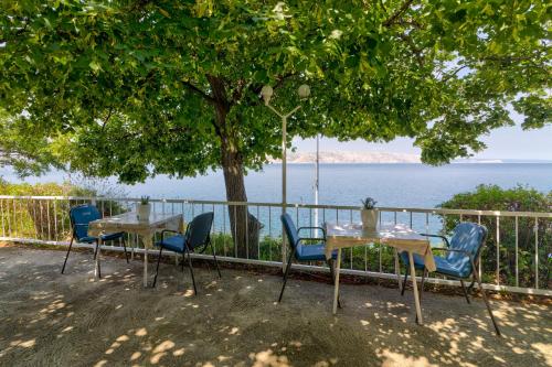 a table and chairs with a view of the water at Vila DADA 2 in Senj