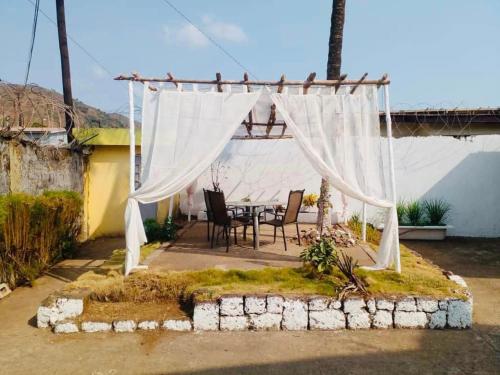 a patio with a table and a white canopy at ZUNOX GUEST HOUSE in Freetown