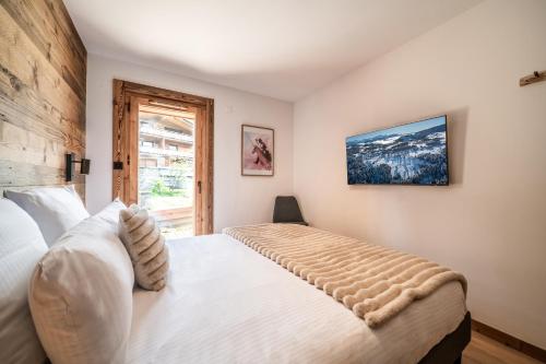 une chambre avec un lit et une fenêtre dans l'établissement Apartment Aldea Les Gets - by EMERALD STAY, aux Gets