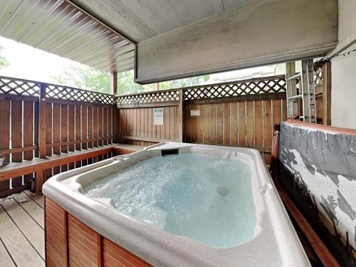 a large jacuzzi tub in an outdoor room at Bear Feet in Oakland