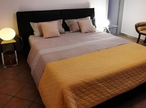 a bedroom with a large bed with a yellow blanket at Apartment Stella Casa Bruno in Vrsi