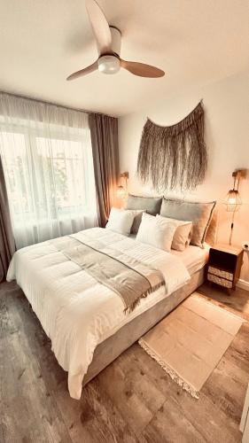 a bedroom with a large bed with a ceiling fan at Morze To Tu in Mielno
