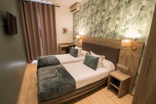 a bedroom with a large bed in a room at Hôtel Parisien in Nice
