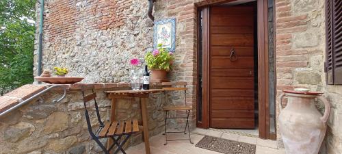 a patio with a table and a wooden door at SerenaHouse in Radicondoli