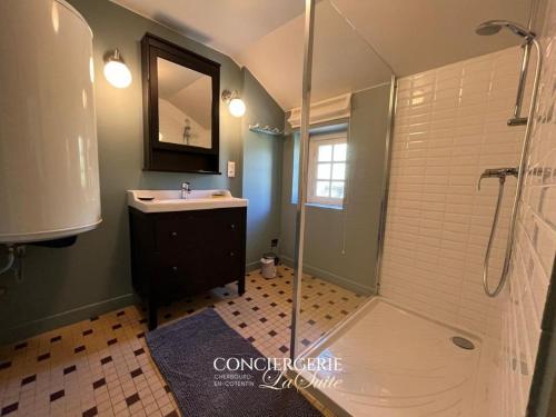 une salle de bain avec une douche et un lavabo et une douche dans l'établissement La Luberie, à Senoville