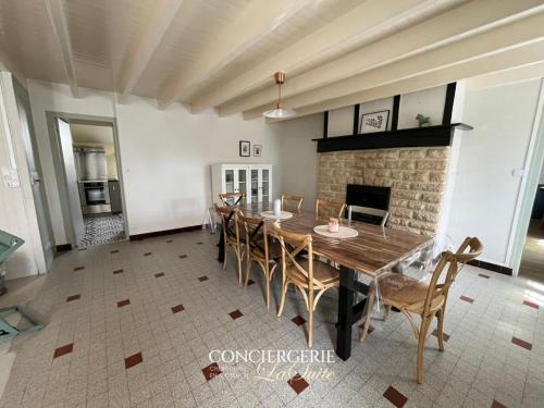 une salle à manger avec une table et des chaises et une cheminée dans l'établissement La Luberie, à Senoville