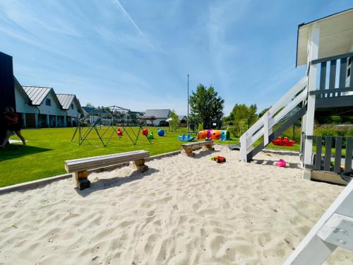un parco giochi con panchine e attrezzature da gioco in un parco di Białe Domki Paula SPA Niechorze a Niechorze