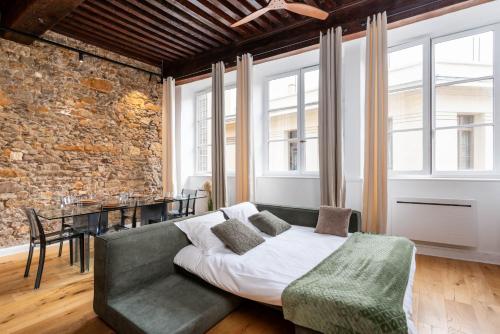 a living room with a couch and a brick wall at Les Balcons de Guignol in Lyon