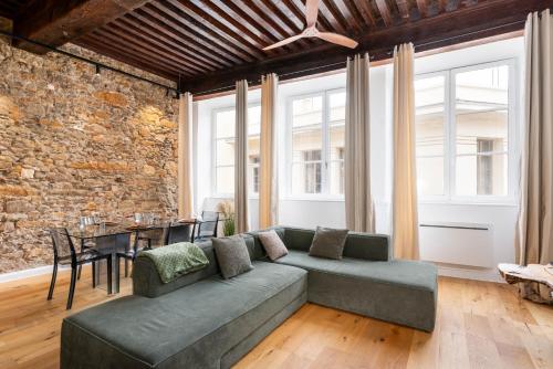 un salon avec un canapé et un mur de briques dans l'établissement Les Balcons de Guignol, à Lyon
