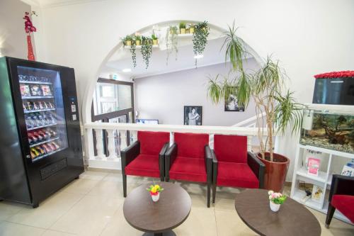 a store with red chairs and tables and a refrigerator at Hôtel Parisien in Nice
