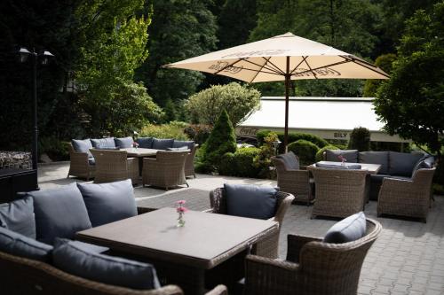 a patio with tables and chairs and an umbrella at Penzion a restaurace Bílý Mlýn in Liberec