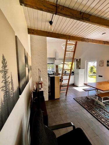 a living room with a table and a kitchen at Villa Gauja - holiday home close to the sea and lake in Gauja