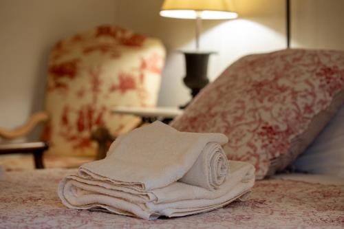 a pile of towels sitting on top of a bed at La Locanda di Villa Toscana in Bibbona