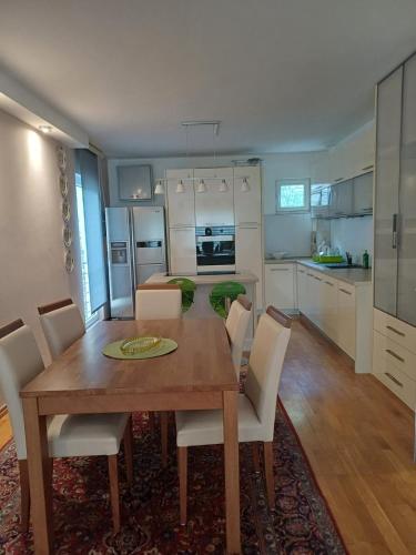 a kitchen and dining room with a wooden table and chairs at Lux Apartman Sofia in Sveti Stefan
