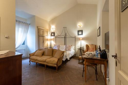 a bedroom with a bed and a couch and a table at La Locanda di Villa Toscana in Bibbona