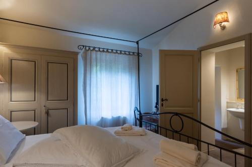 a bedroom with a bed with towels on it at La Locanda di Villa Toscana in Bibbona