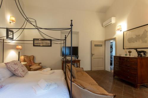 a bedroom with a bed and a dresser and a tv at La Locanda di Villa Toscana in Bibbona