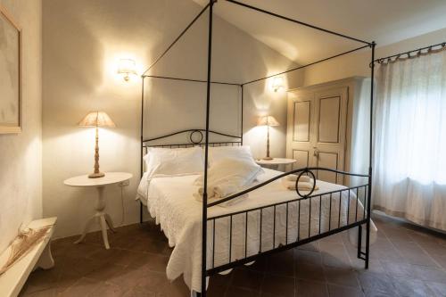a bedroom with a black canopy bed with two lamps at La Locanda di Villa Toscana in Bibbona