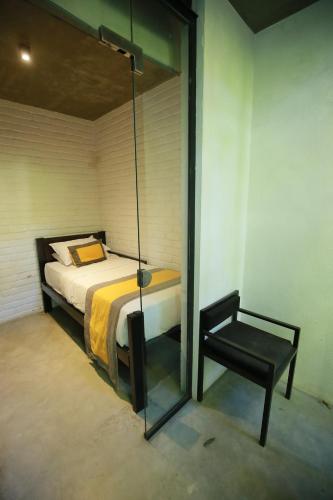 a bedroom with a bed and a chair in it at BBQ HUB Ella in Ella