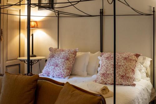 a bedroom with a bed with pillows and a canopy beduten at La Locanda di Villa Toscana in Bibbona
