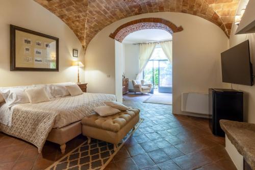 a bedroom with a large bed and a living room at La Locanda di Villa Toscana in Bibbona