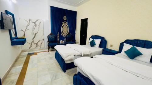 a hotel room with two beds and a tv at Hotel Multan One in Multan