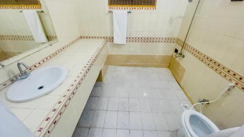 a bathroom with a sink and a toilet at Hotel Multan One in Multan