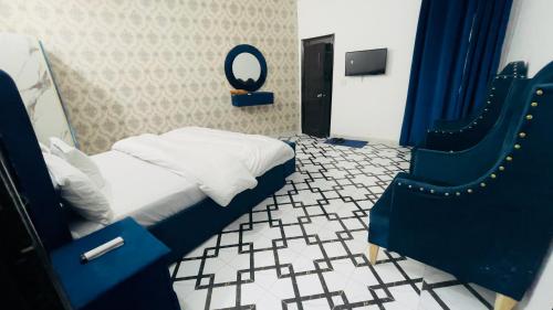 a bedroom with a bed with a mirror and a chair at Hotel Multan One in Multan