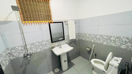a bathroom with a sink and a toilet at Hotel Multan One in Multan
