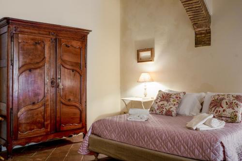 a bedroom with a large wooden cabinet next to a bed at La Locanda di Villa Toscana in Bibbona