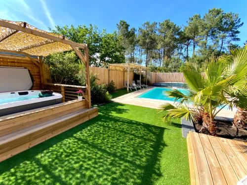 une cour avec une piscine et une clôture en bois dans l'établissement Villa Pins&Spa Piscine Jacuzzi Petanque Ping-pong, à Andernos-les-Bains