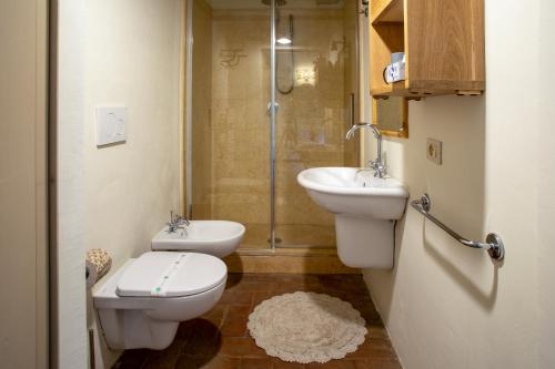 a bathroom with a toilet and a sink and a shower at La Locanda di Villa Toscana in Bibbona
