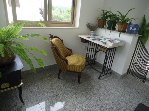 a room with a chair and a desk with plants at Apartments Polonijo in Baška