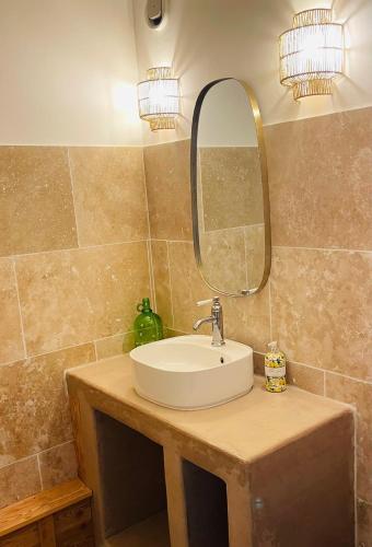 une salle de bain avec un lavabo et un miroir dans l'établissement Rdc 48m2 avec terrasse Proche Centre avec parking privé couvert, à Orcières