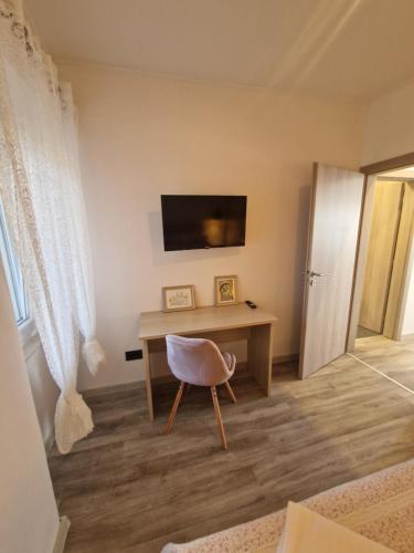a room with a desk with a television and a chair at Apartmani Rukavina in Rab