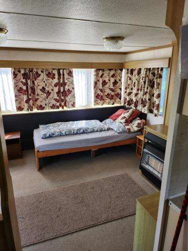 a small bedroom with a bed in a doll house at Mazury Kemp Jedwabno in Jedwabno