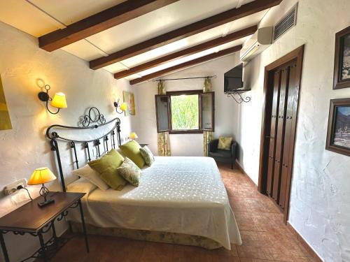 a bedroom with a bed and a table and a window at Hotel Rural La Paloma in Villanueva de Tapia