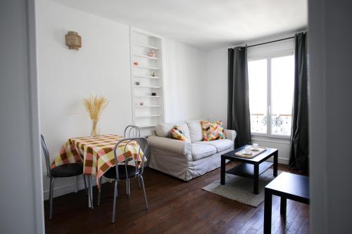 un salon avec un canapé et une table dans l'établissement Batignolles toits de paris, à Paris