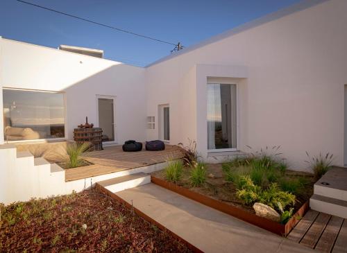 a white house with a deck and a patio at Pédebicho Serra da Arrábida Country Inn and Studios in Azeitao
