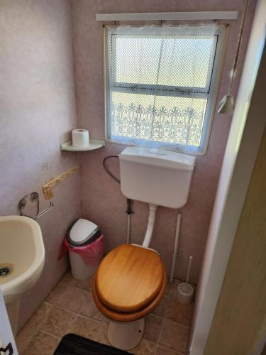 a small bathroom with a toilet and a window at Mazury Kemp Jedwabno in Jedwabno