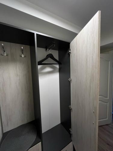 a closet with black and white walls and wooden doors at Jaukus butas arti Šiaulių miesto in Šiauliai