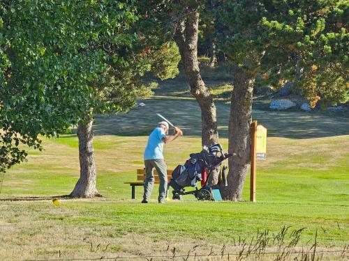 un homme se tient à côté d'un banc de parc avec dans l'établissement Chalet Collection Cassiopée - Les Chalets Secrets, à Font-Romeu